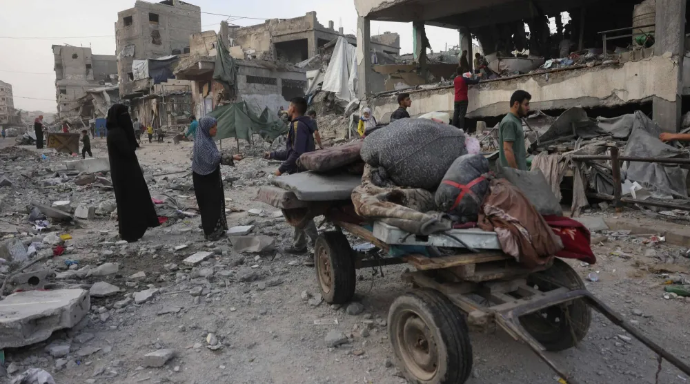 فلسطينيون يزيلون الأنقاض والحطام بعد غارات إسرائيلية ليلية في جباليا في شمال قطاع غزة، 12 مايو 2025 (أ.ف.ب)